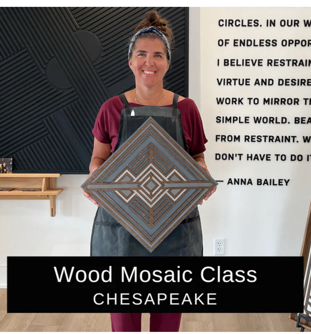Person holding a wood mosaic piece with text and a quote on the wall.